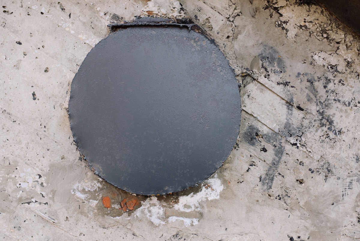 Open septic tank access lid at grade in a lawn during cleaning service